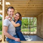 Couple,standing,on,future,window,in,construction,site,of,their